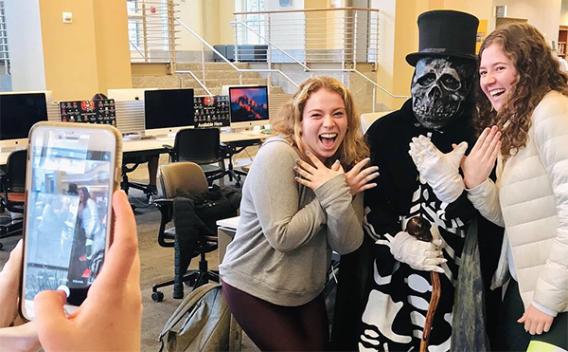 Emory's mascot Dooley posing with students at Oxford College Library